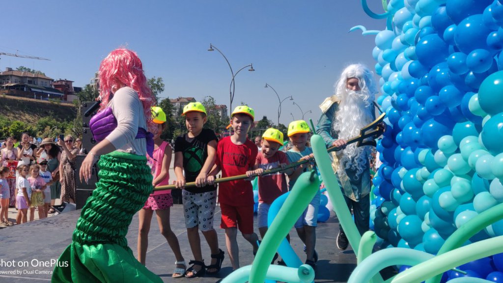 Woman in mermaid costume participating in Danube Day event with children