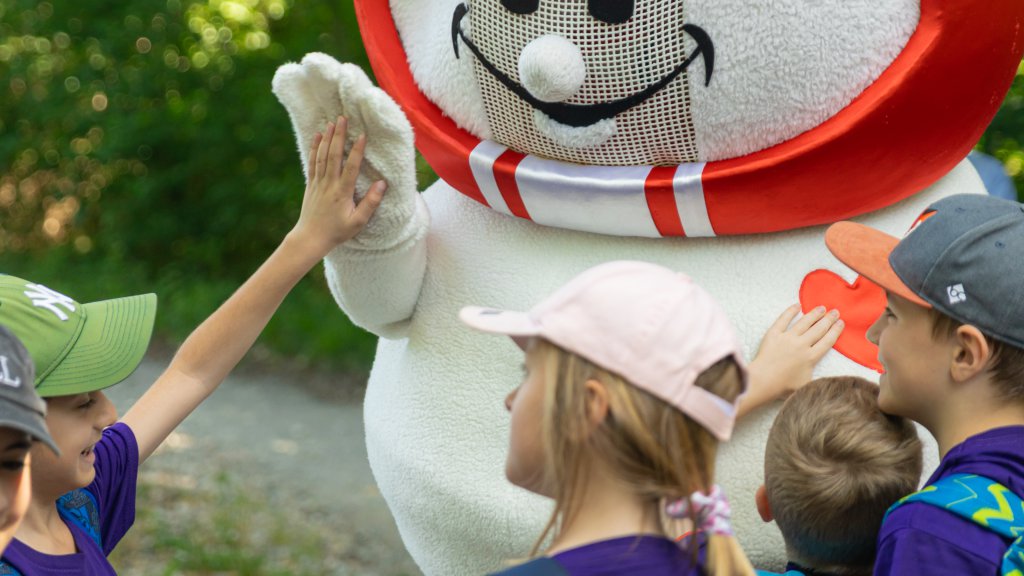 A child playing with a mascot 