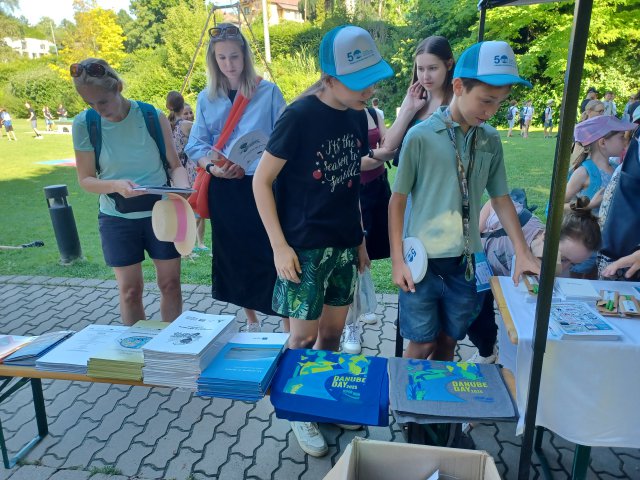 Children look at the Danube Day tote bags and other Danube Day materials. 