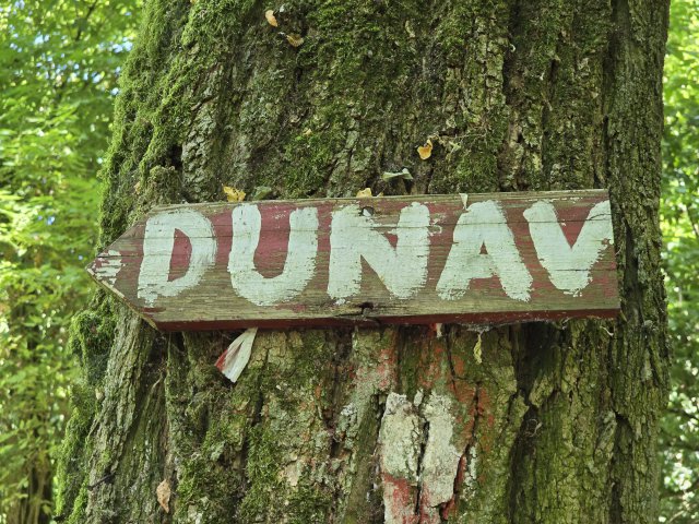 Sign nailed to a tree that reads DUNAV (Croatian word for Danube) in white.