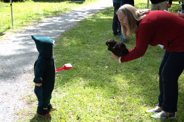 A woman talks to a young boy outside. 