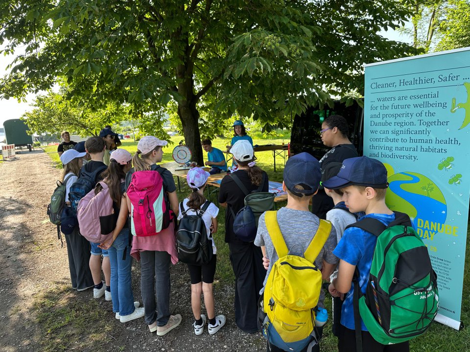 BMLUK/Susanne Brandstetter Children staning together next to a roll up of Danube Day