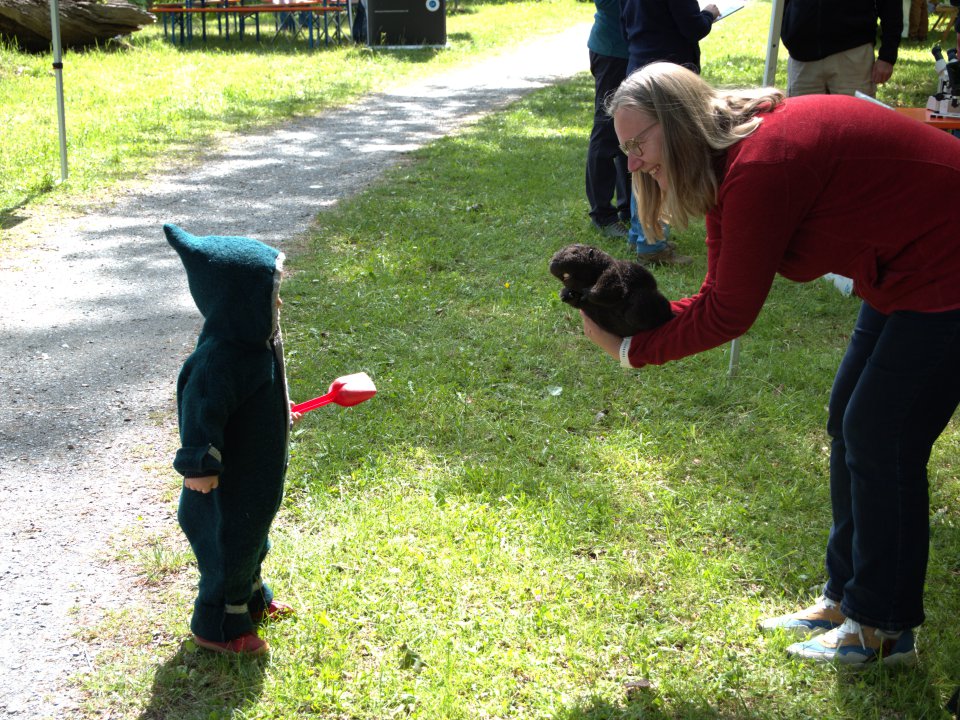 A woman talks to a young boy outside. 